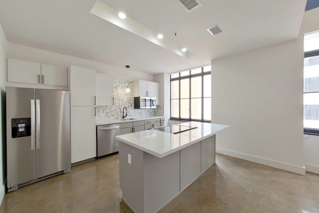 kitchen with an island bar, stainless steel appliances, white cabinets, a nice backsplash, shiny floors, and white countertops