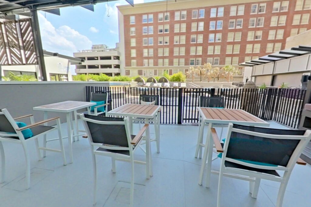 Outdoor seating area just outside of the pool area, covered with tables and chairs