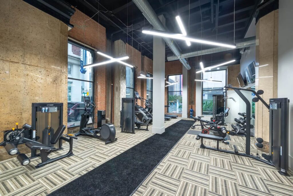 Large fitness center with weights, TVs and cardio and strength machines including stairs and treadmills, cycles and more