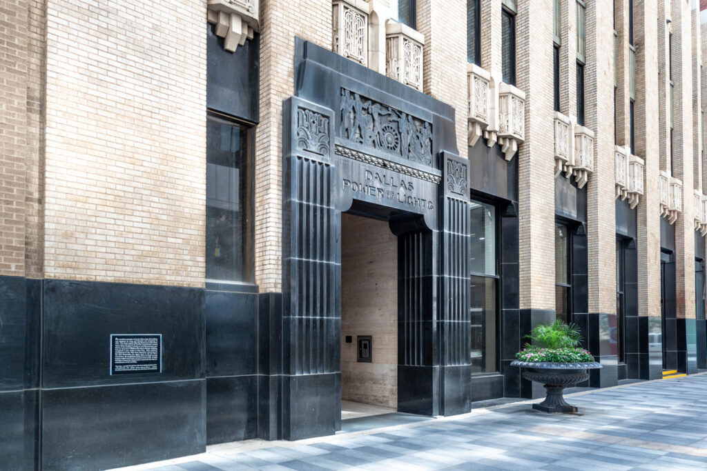 Entrance to the Dallas Power & Light building featuring black stone detailing and ornate carvings above the doorway.