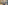 A lobby area with two blue velvet sofas, a wooden coffee table, stone walls, and a staircase leading to an upper level.